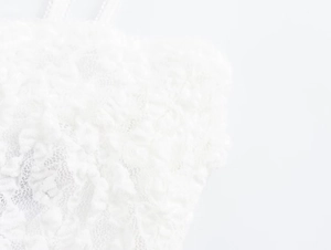Nahaufnahme der weißen Blumen-Spitzentextur an einem eleganten Sommerkleid