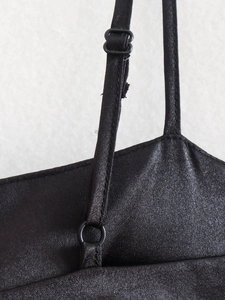 Detail view of adjustable straps and satin texture on black sleeveless top
