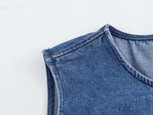 Detail of light blue denim stitching and twill fabric texture on sleeveless round neck dress