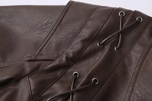 Detailed view of dark brown faux leather texture with lace-up eyelets and stitching