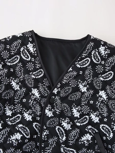 Detail of V-neckline and quilted floral paisley pattern on black cotton jacket