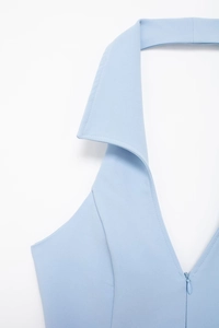 Detail view of sky blue halter top featuring a V-neckline with lapels and zipper closure