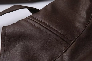 Macro shot of dark brown faux leather texture with precise double-needle stitching detail