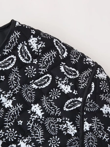 Detail of quilted paisley print fabric with black piping on a stylish street jacket