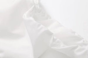 Macro shot of white slim top drawstring detail showing stitching and soft fabric texture