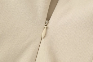 Detailed view of khaki midi dress featuring a seamless invisible zipper and twill fabric