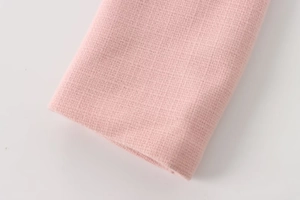 Detaillierte Nahaufnahme der rosa Tweed-Stoffstruktur und Webart für Damenjacken