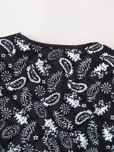 Close-up of black and white paisley floral pattern on quilted vest fabric texture