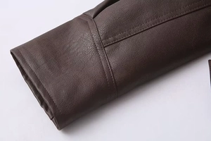 Detail of dark brown leather jacket cuff with double stitching and pebble grain texture