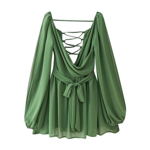 Detail of green V-neck mini dress showing open back design and crisscross lace-up straps
