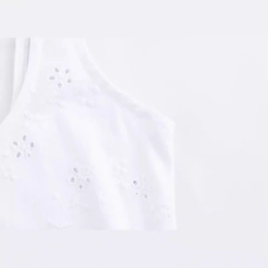 Robe d'été blanche avec des détails complexes de broderie anglaise et fleurs