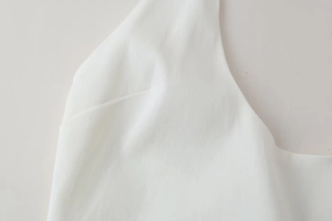 Detailed close-up of white summer dress fabric showing fine vertical silk texture