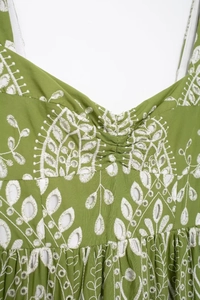 Detailed view of floral white embroidery and eyelet design on a green summer midi dress