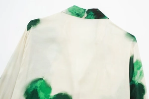 Détail du col et de l'épaule d'une chemise blanche avec motif lavis à l'encre verte