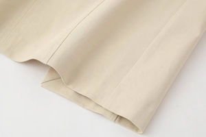 Close-up of beige midi dress fabric with premium twill texture and neat double-row stitching