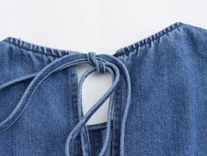Detail of round neckline with denim string tie on light blue patchwork dress