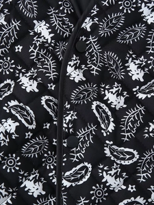 Detail of bohemian floral print on quilted black and white jacket with matte buttons