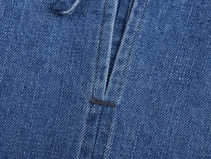 Detailed macro view of reinforced bar-tack stitching on indigo denim fabric texture