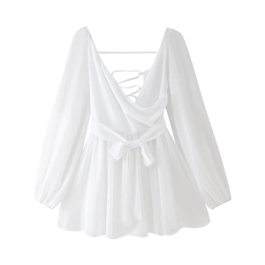 Detail of white V-neck mini dress showing cross back ties and chiffon fabric texture