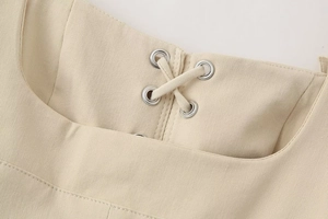 Detail of square neckline with lace-up drawstring and silver eyelets on khaki midi dress