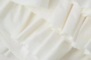 Detailed macro shot of white tiered ruffle fabric with lightweight chiffon texture