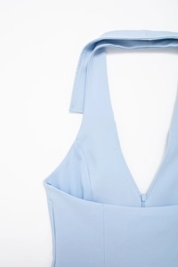 Close-up of light blue halter neck top featuring a deep V-neckline and hidden zipper