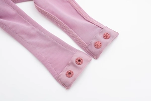 Close-up of pink mesh fabric on bodysuit featuring tonal plastic snap fasteners