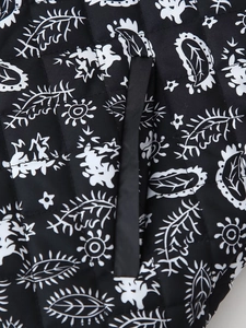 Macro view of black and white leaf print on quilted fabric with square stitching