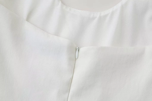 Detail of invisible zipper closure on white summer dress with smooth woven texture
