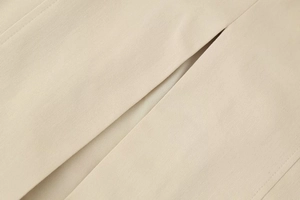 Close-up of beige twill fabric texture and precise stitching on midi summer dress
