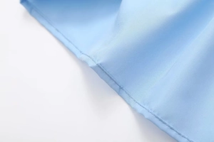 Detail view of the fine single-needle stitching on the sky blue slim crop top hem