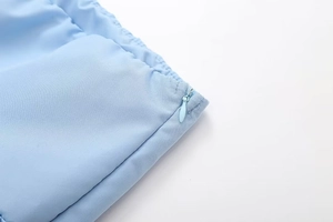 Close-up of sky blue top showing the invisible zipper detail and fine fabric texture
