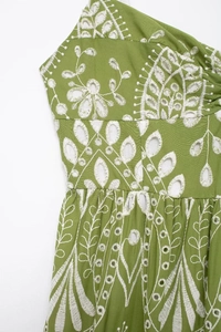 Detailed view of green cotton fabric with white floral embroidery and eyelet design