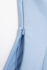 Detail showing the light blue fabric texture and side invisible zipper of the top
