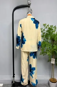 Detail view of cream satin pajama set with blue abstract floral prints on shirt and pants