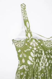 Close-up of green summer dress with white floral embroidery and hidden side zipper