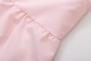 Detail shot of pink gathered fabric showing precise stitching and ruffle craft on the top