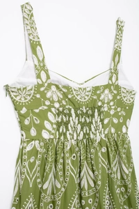 Detailed close-up of green midi dress with white floral embroidery and smocked back panel