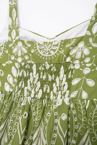 Detail of green cotton midi dress with white floral embroidery and hollow-out eyelet design