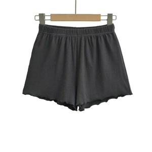 Detailed close-up of dark grey ribbed knit shorts with elastic waist and lettuce hem