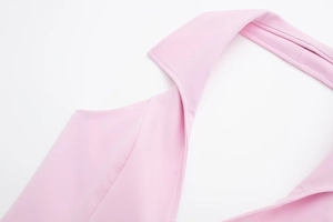 Detailed close-up of light pink woven halter neck blouse with precise stitching and collar