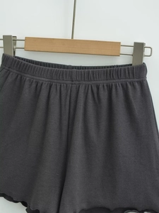 Macro view of dark grey ribbed knit shorts featuring elastic waist and lettuce hem detail