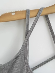 Détail du tissu en maille côtelée grise et coutures de la fine bretelle