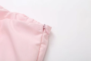 Detailed close-up of pink crop top featuring a high-quality invisible zipper closure