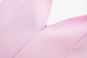 Detail shot of the invisible zipper and fine stitching on a light pink halter neck top
