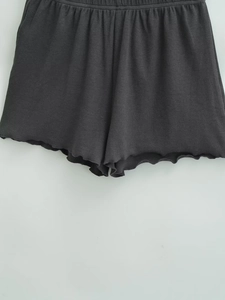 Detail of dark grey ribbed knit shorts with elastic waistband and lettuce edge hem
