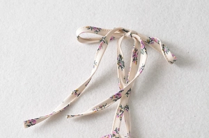 Détail de la bride nouée en nœud papillon sur robe d'été à motif floral violet et jaune
