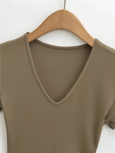 Close-up of khaki V-neck ribbed fabric detail on a slim fit t-shirt for women