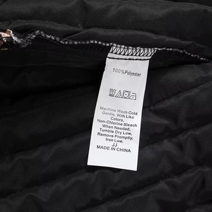Détail du tissu matelassé avec étiquette d'entretien indiquant 100% polyester