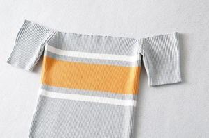 Detail of ribbed knit texture on striped off-the-shoulder crop top for women